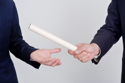 ビジネスマンがバトンを渡す風景